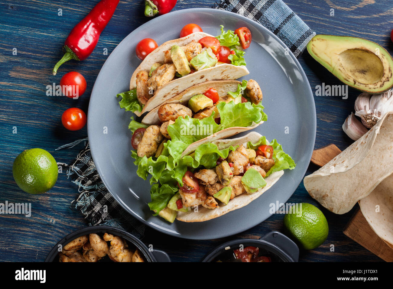 Autentica tacos messicano con pollo e salsa con avocado, pomodori e peperoncino. Cucina messicana. Vista superiore Foto Stock