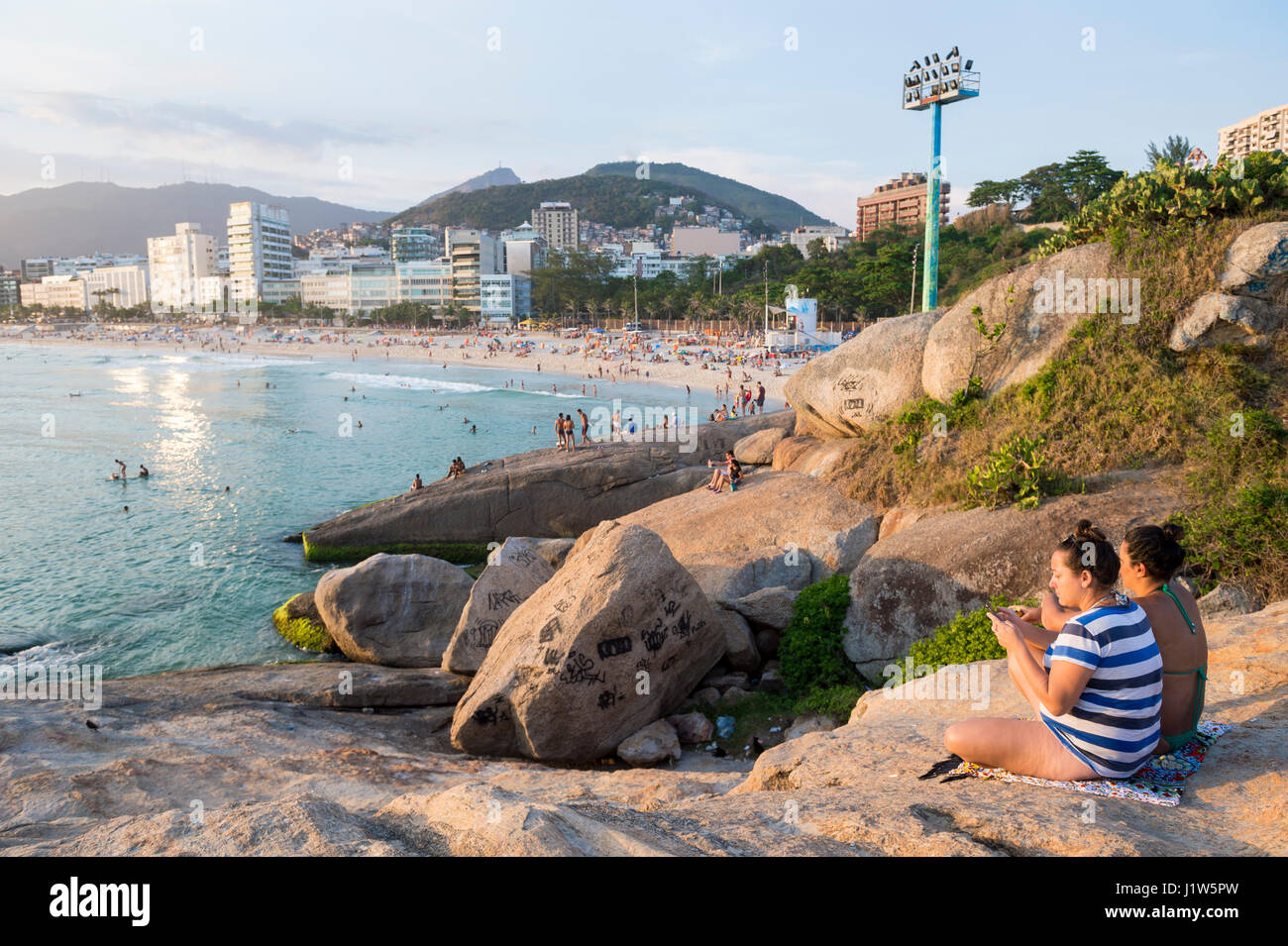 RIO DE JANEIRO - Febbraio 20, 2017: amici godere la calma relativa di un tramonto da Arpoador, che attrae folle come il sole si avvicina all'orizzonte Foto Stock