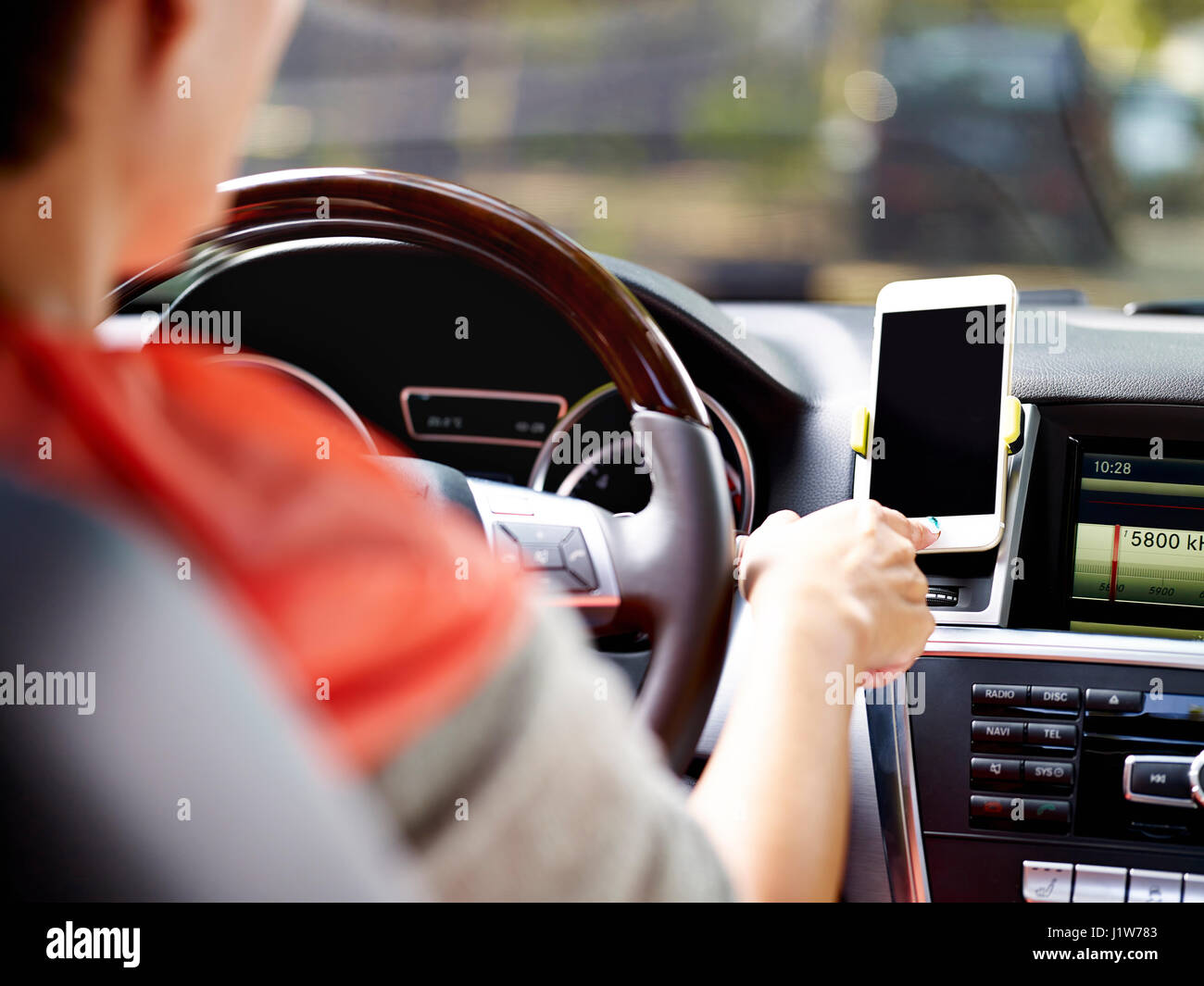 Driver femminile tramite cellulare per navigare prima di guidare. Foto Stock