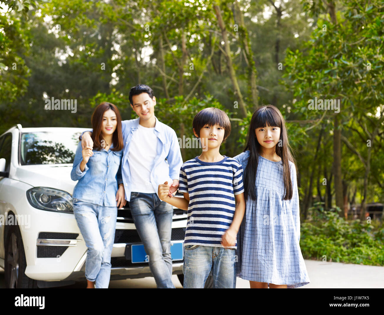 Famiglia asiatica con due bambini che viaggiano in auto. Foto Stock
