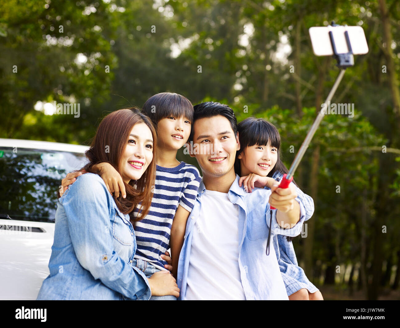 Famiglia asiatica con due bambini prendendo un selfie durante un viaggio. Foto Stock