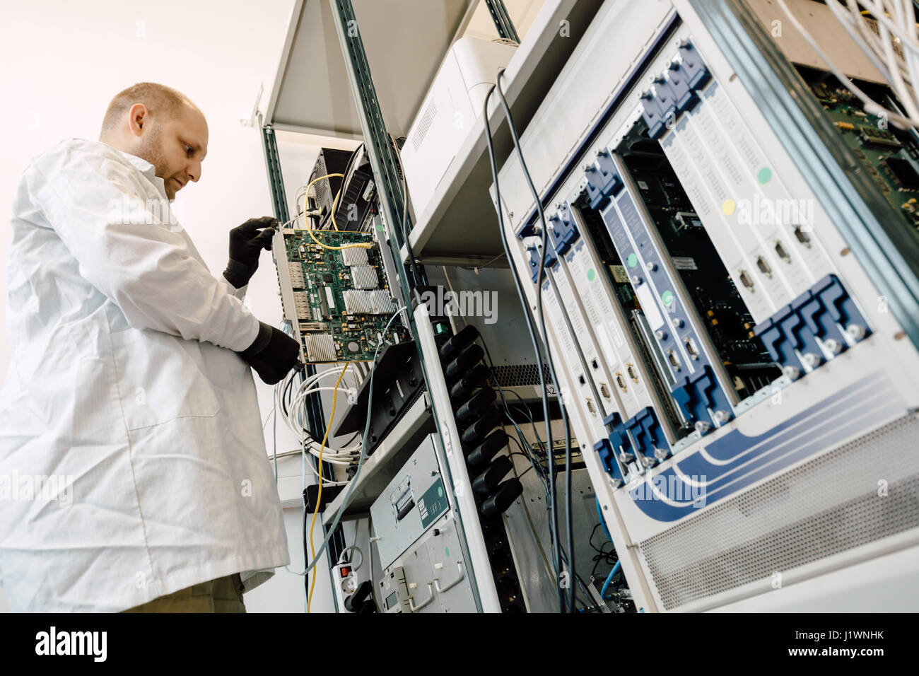 Tecnico operante nella scheda di rete labaratory Foto Stock