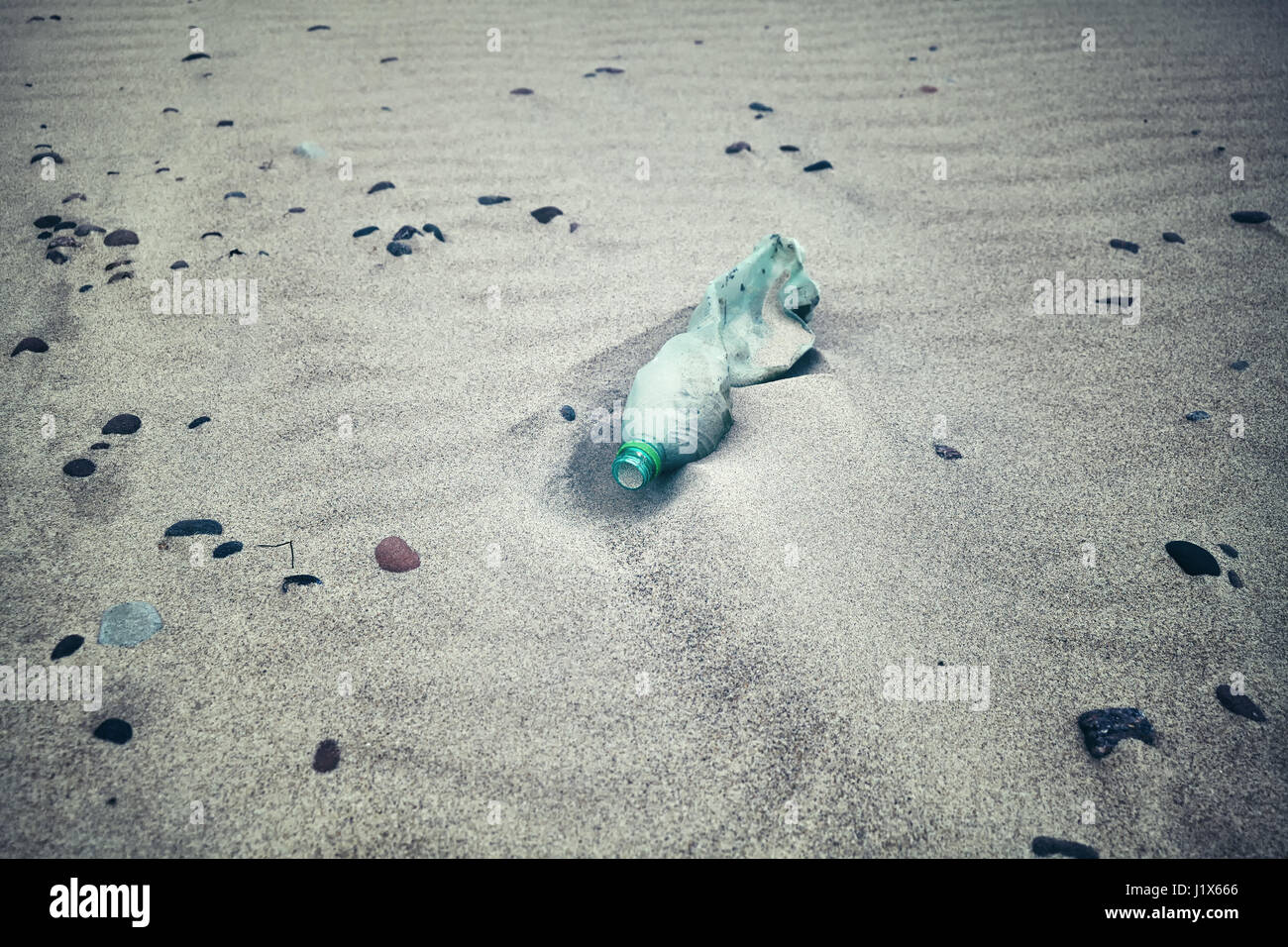 Tonalità di colore della immagine vuota una bottiglia di plastica a sinistra su una spiaggia, il fuoco selettivo. Foto Stock