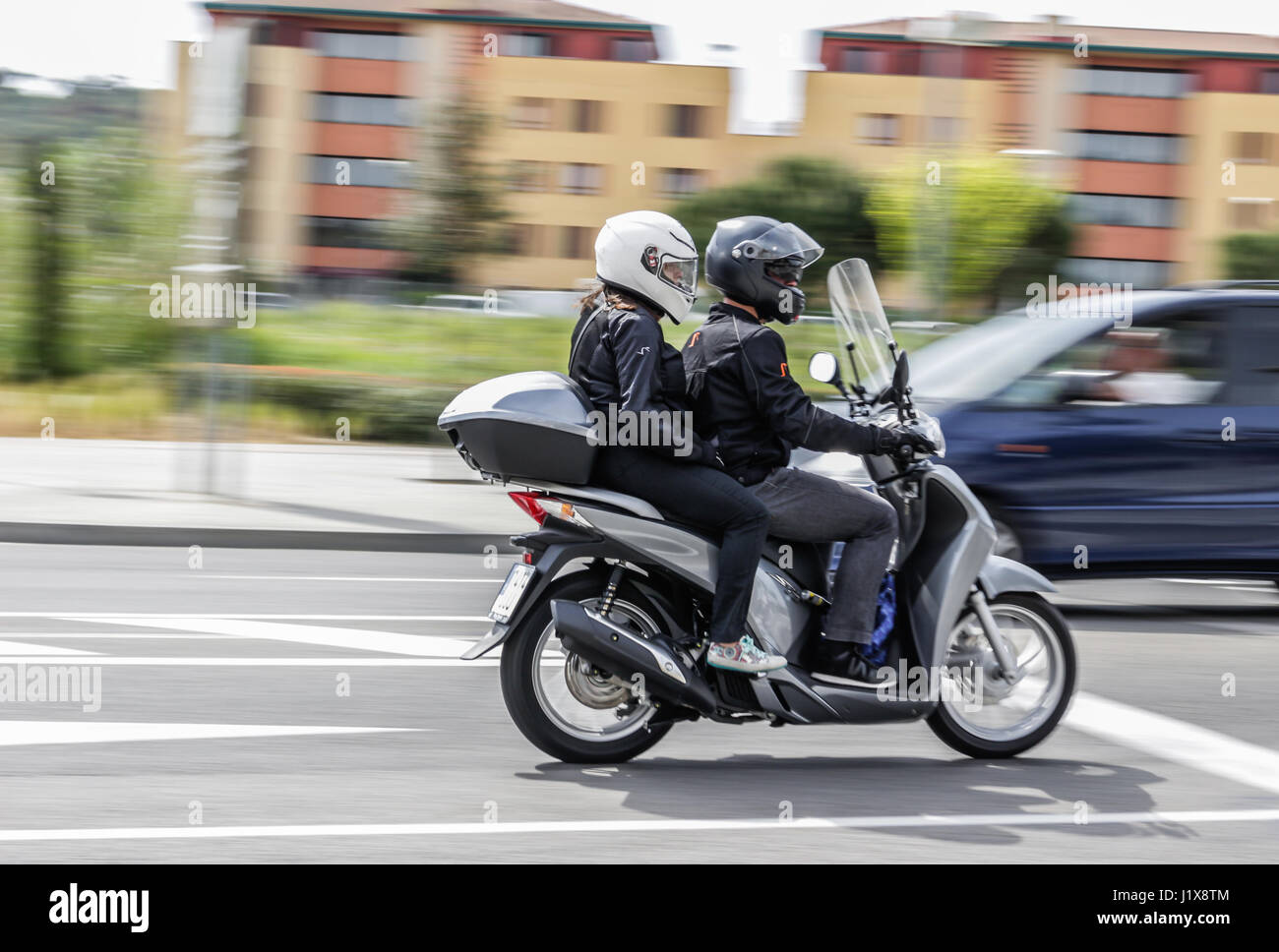 2 persone in sella a una motocicletta lungo una strada Foto Stock