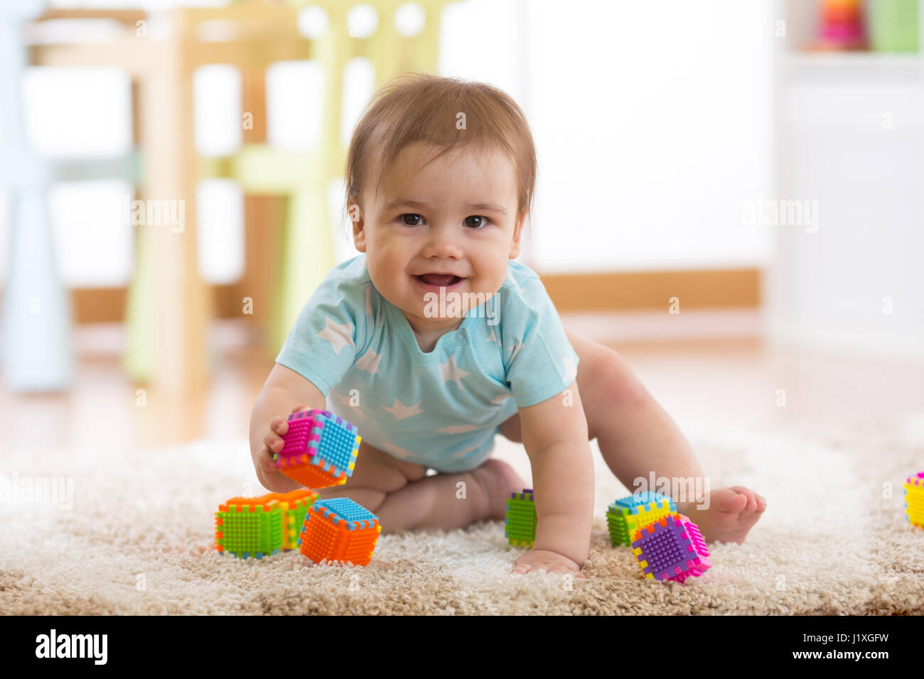 Gattona funny baby boy sul pavimento a casa Foto Stock