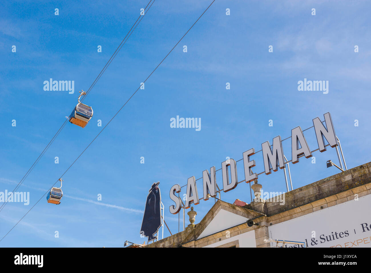 Porto Portogallo Gaia, una coppia di funivie trasportano i turisti passano sopra un enorme porto Sandeman sign in il waterfront Gaia distretto di Porto, Portogallo. Foto Stock