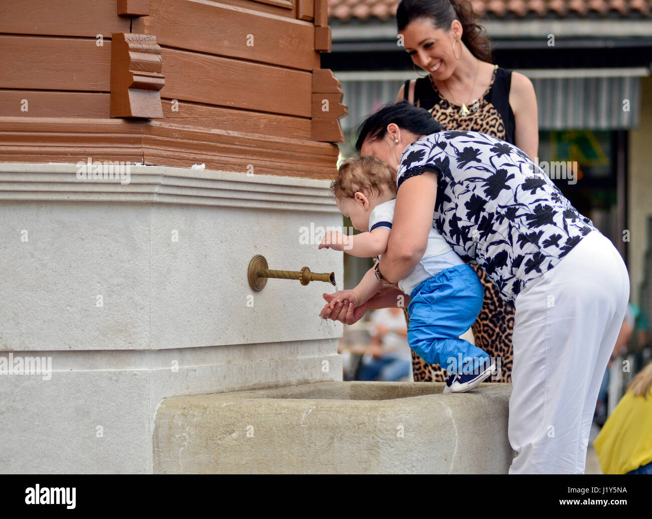 Nonna pulisce suo nipote nella fontana di Sebilj. Bascarsija, Sarajevo Foto Stock