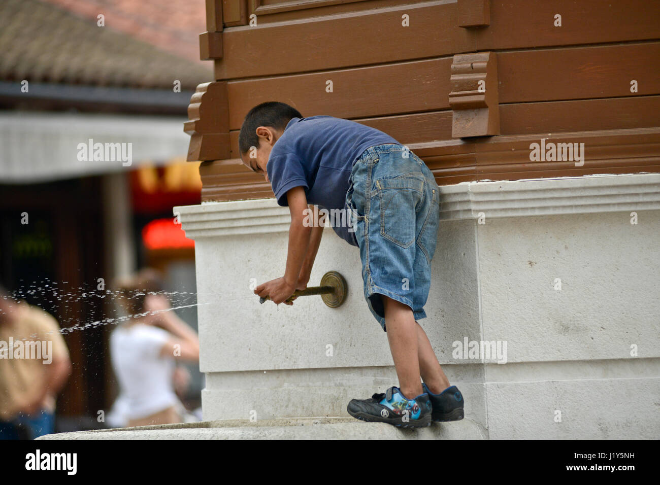 Ragazzo che gioca nella fontana di Sebilj. Bascarsija, Sarajevo Foto Stock