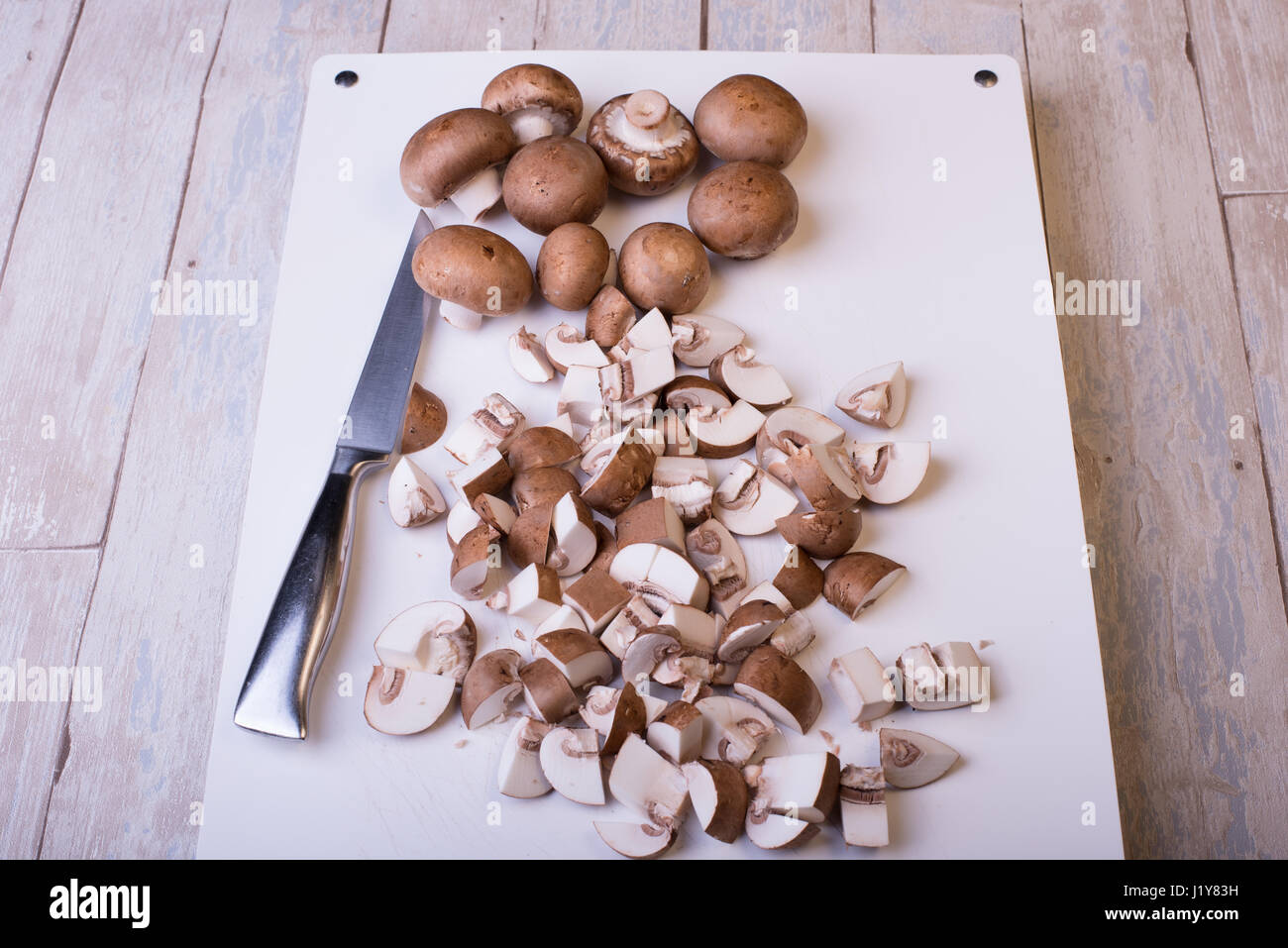 Freschi champignon tagliati su sfondo bianco Foto Stock