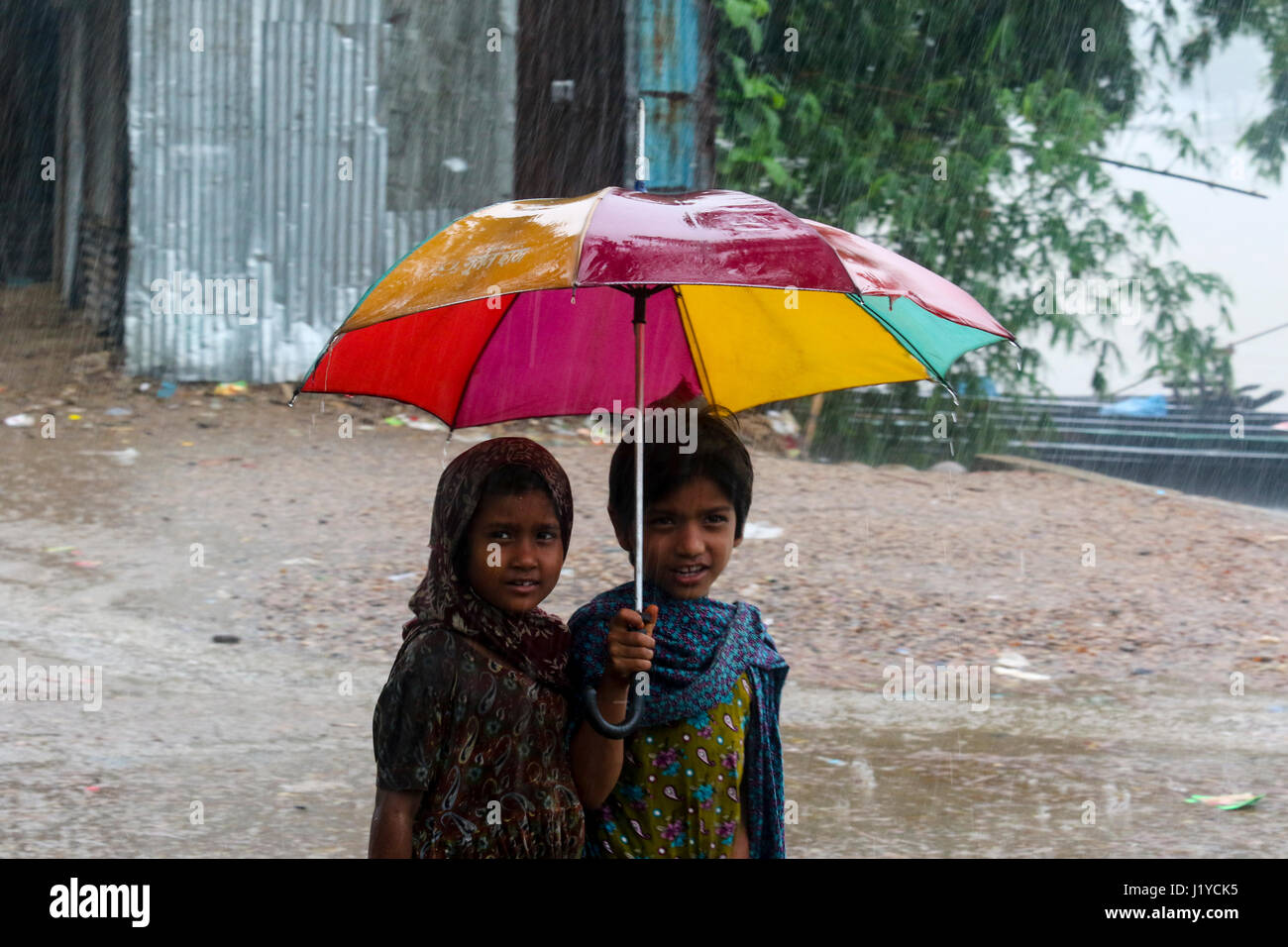 Bambine utilizzare ombrello durante le precipitazioni presso la banca di fiume Piain Gowainghat a. Sylhet, Bangladesh. Foto Stock