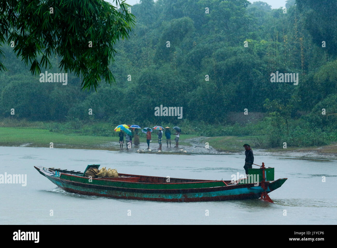 Passeggeri attendere per salire sulla barca a Piain Riverbank durante le precipitazioni a Gowainghat. Sylhet, Bangladesh. Foto Stock