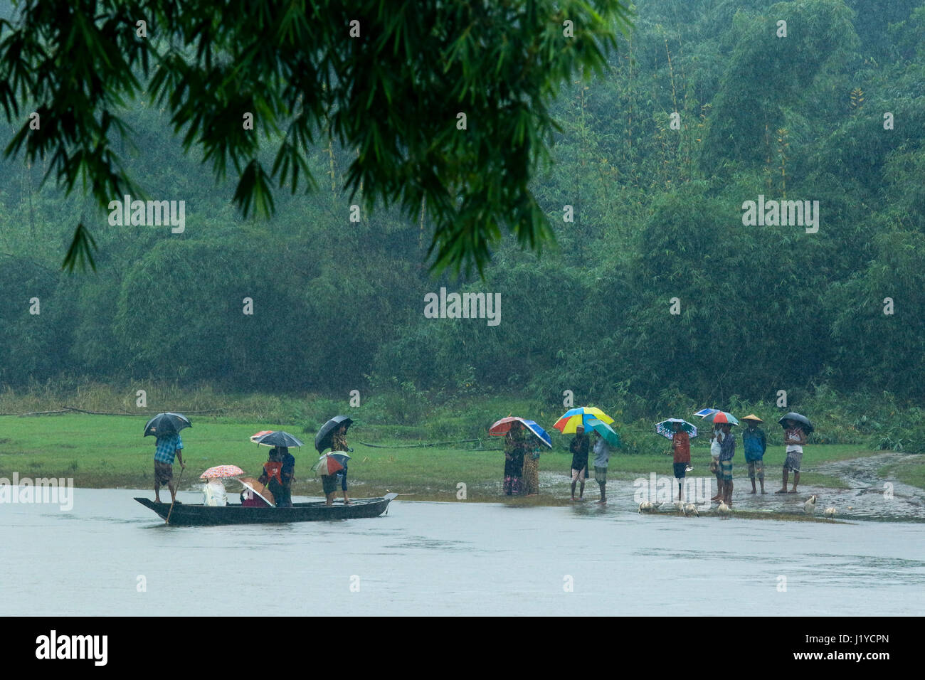 Passeggeri attendere per salire sulla barca a Piain Riverbank durante le precipitazioni a Gowainghat. Sylhet, Bangladesh. Foto Stock