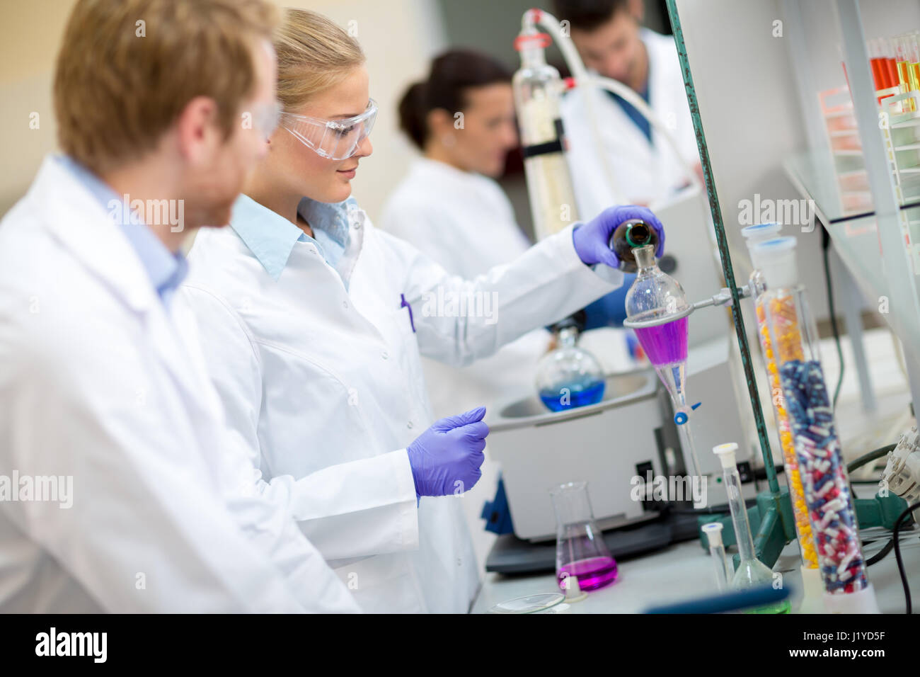 Femmina tecnico chimico la miscelazione di fluidi in laboratorio Foto Stock