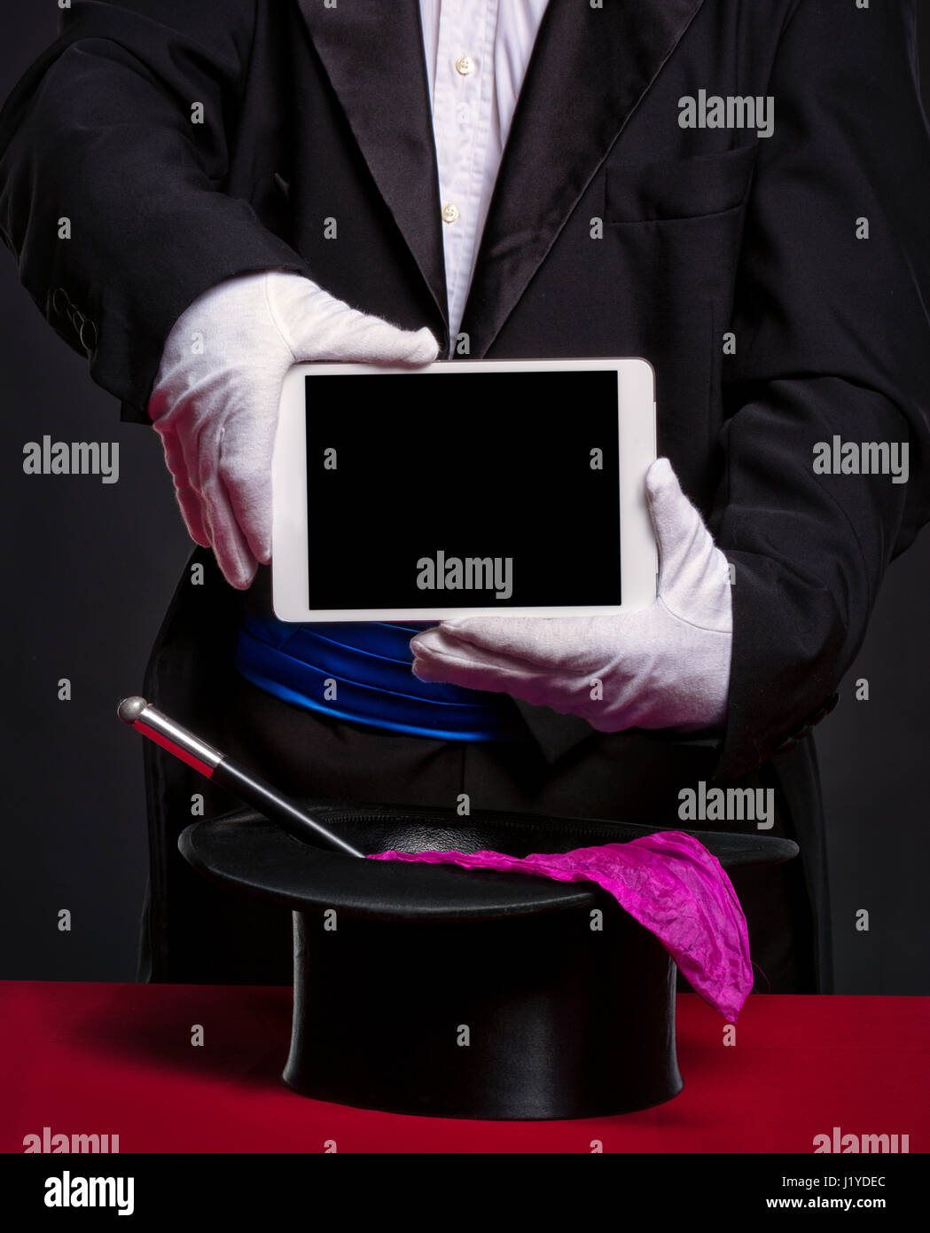 Mago azienda tablet pc oltre i suoi accessori per lavoro, pubblicità e illusione Foto Stock