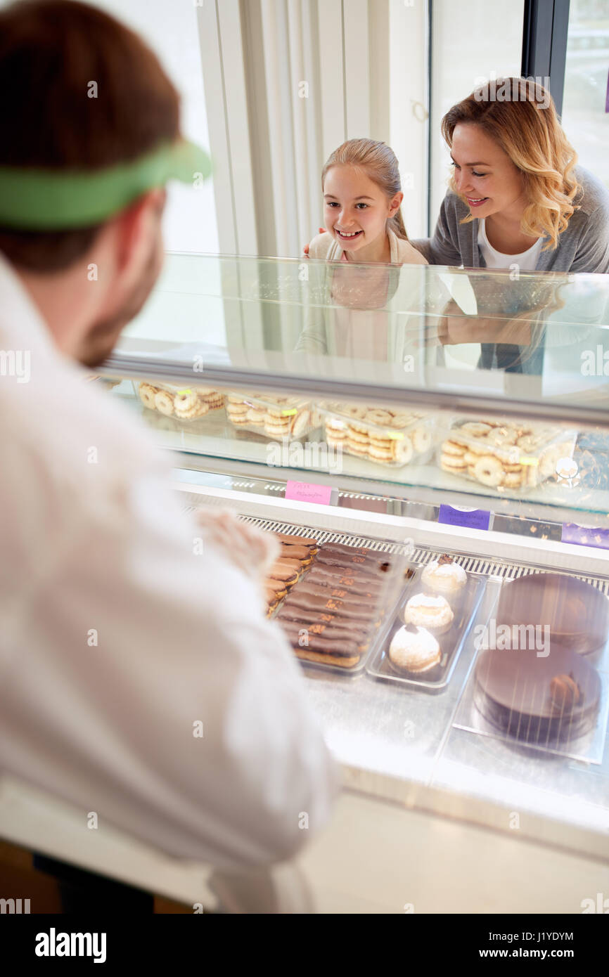 Madre e figlia in pasticceria con venditore Foto Stock
