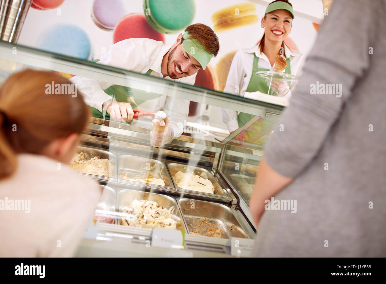 Nel negozio di pasticceria venditori serve i clienti con gelato Foto Stock