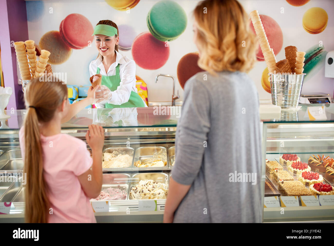 Venditore femmina in panetteria dà gelato alla ragazza Foto Stock