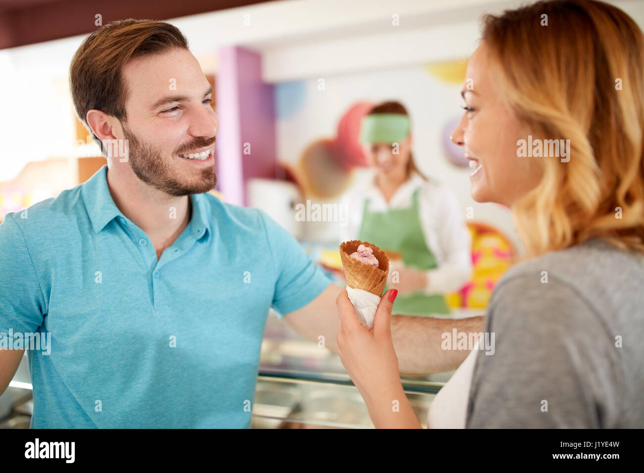 Allegro l uomo e la donna nel panificio tenuto gelati Foto Stock