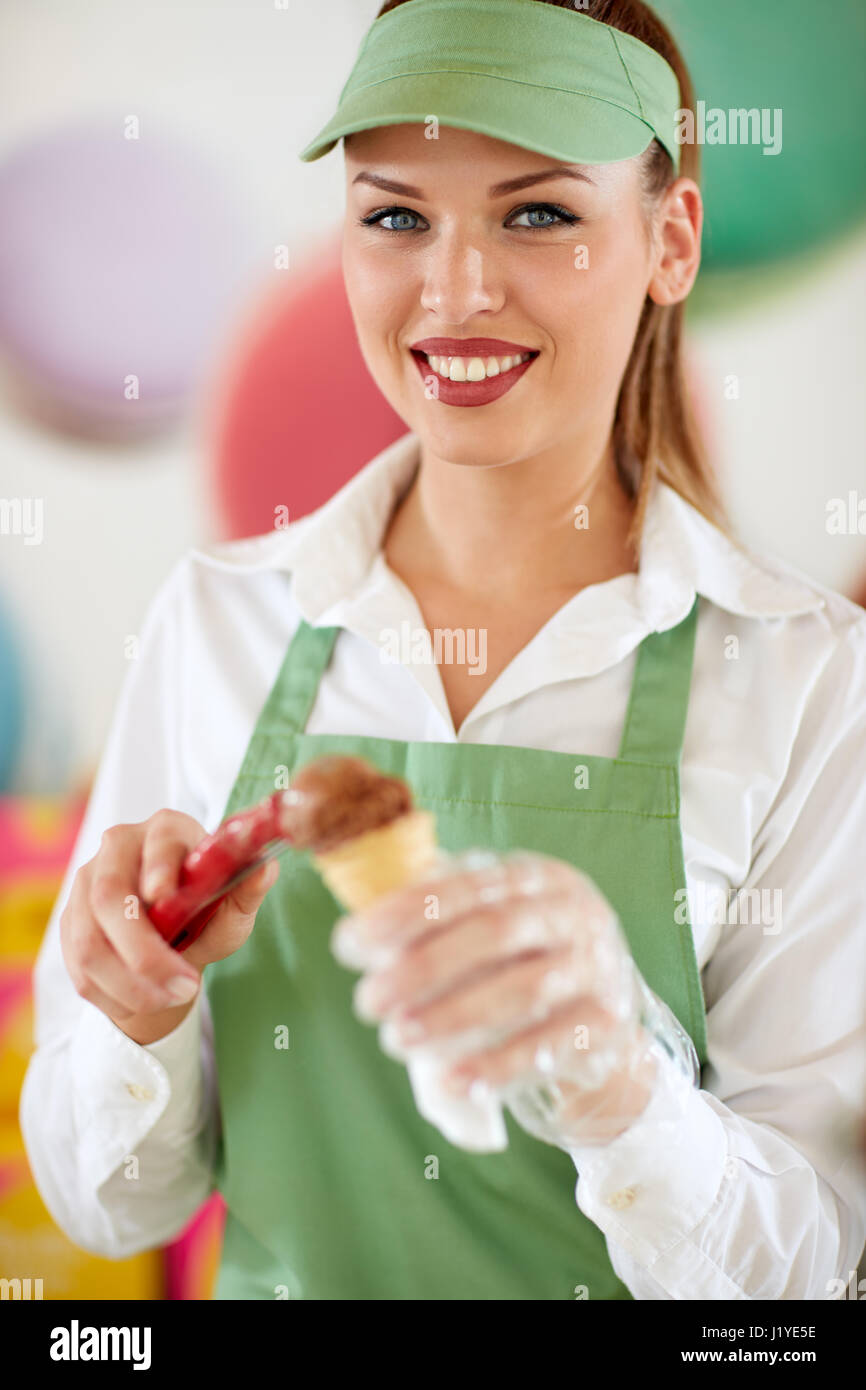 Attraente pasticceria a pasticceria mettendo la sfera di cioccolato gelato in cono Foto Stock