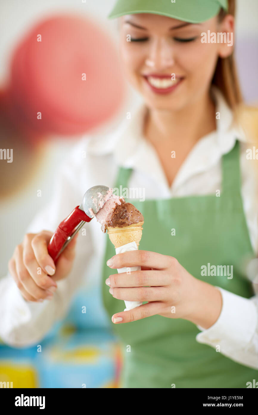 Close up di gelati in cono nella commessa la mano in una pasticceria Foto Stock