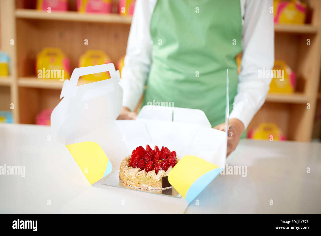 Close up di torta di fragole in cartone per imballaggio prendendo il via nel forno Foto Stock