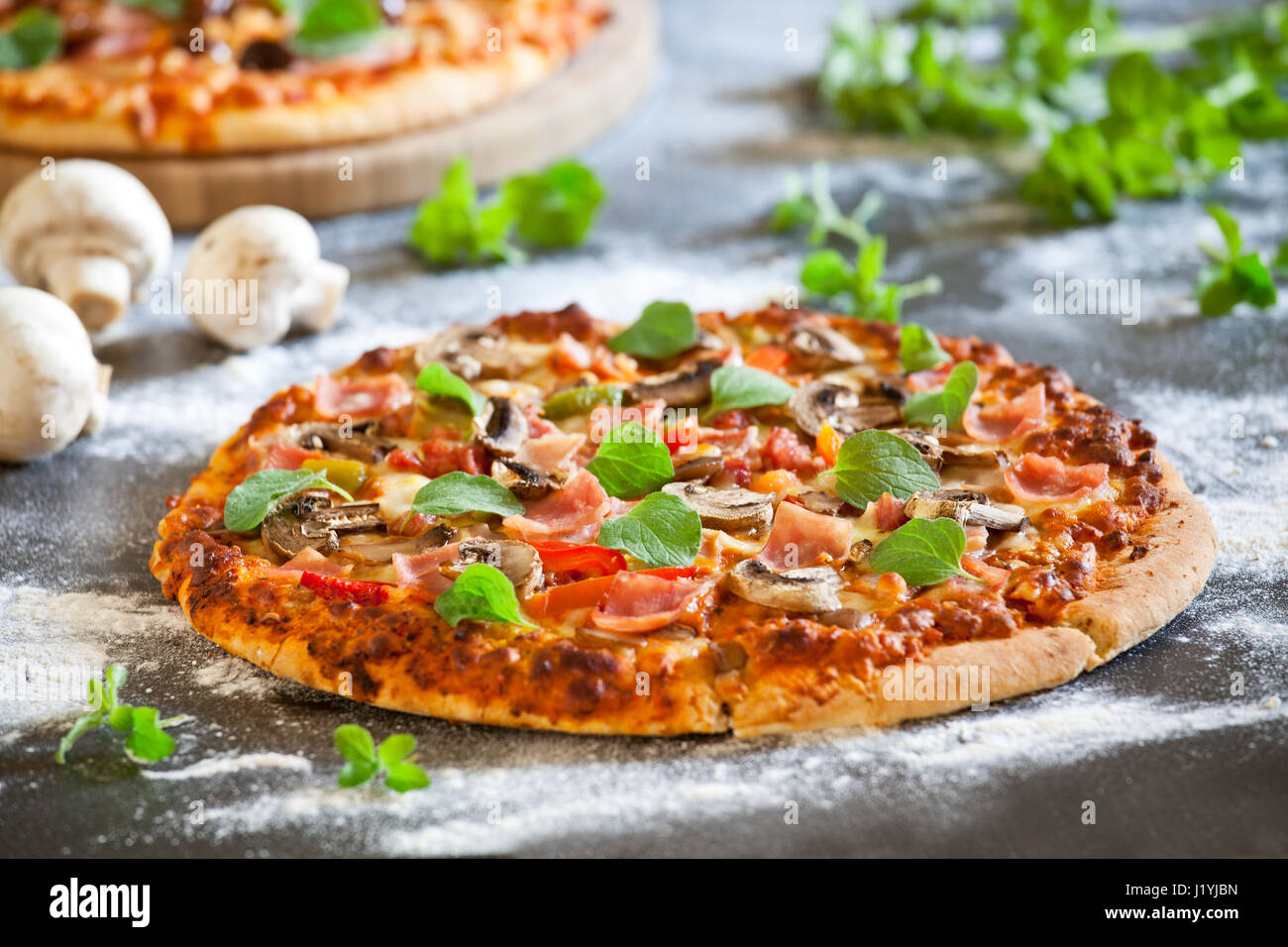 In prossimità di una pizza fatta in casa con pomodoro prosciutto e funghi Foto Stock