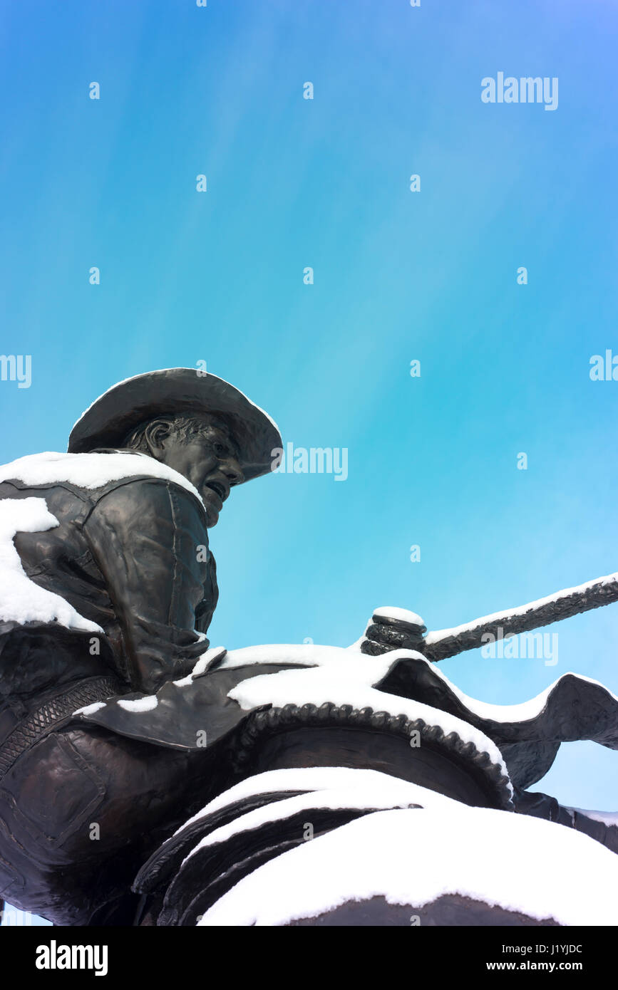 Cowboy omaggio statua di un cowboy a cavallo con la neve. Foto Stock