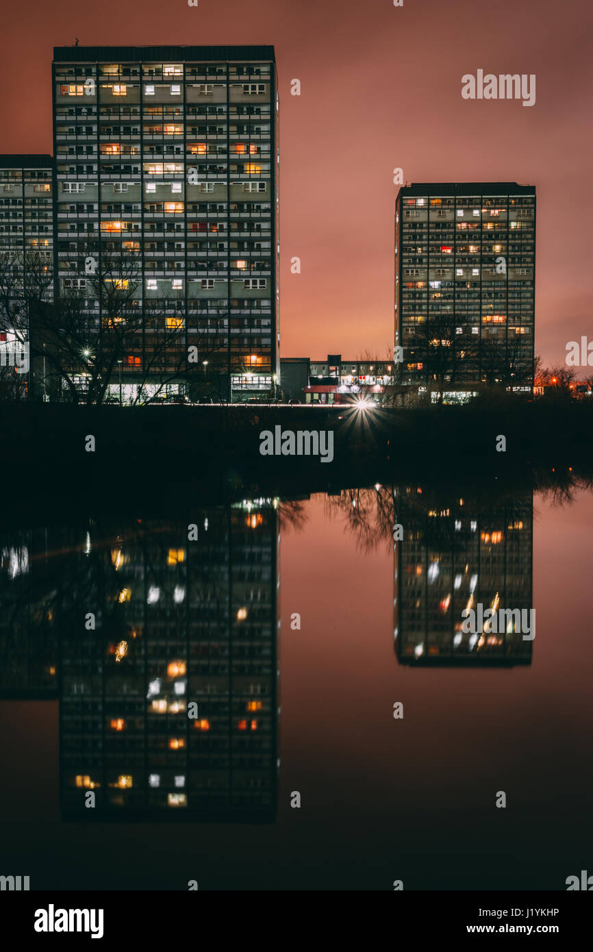 Alto edificio di appartamenti che la Gorbals riflessa nel fiume Clyde a Glasgow in Scozia a notte. Immagine presa da Glasgow Green. Foto Stock