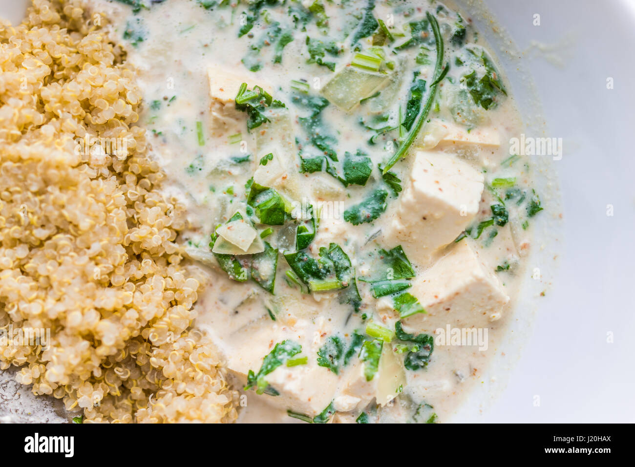 Macro closeup di tofu curry verde con la quinoa nel recipiente Foto Stock