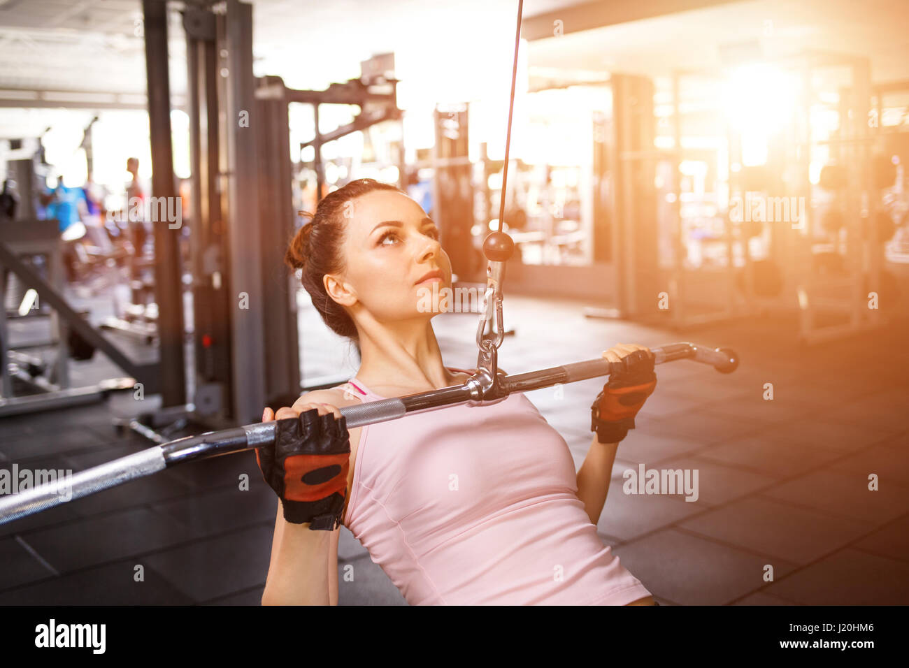 Giovane donna fitness di eseguire la stretta aderenza lat pulldown sulla macchina di cavo Foto Stock
