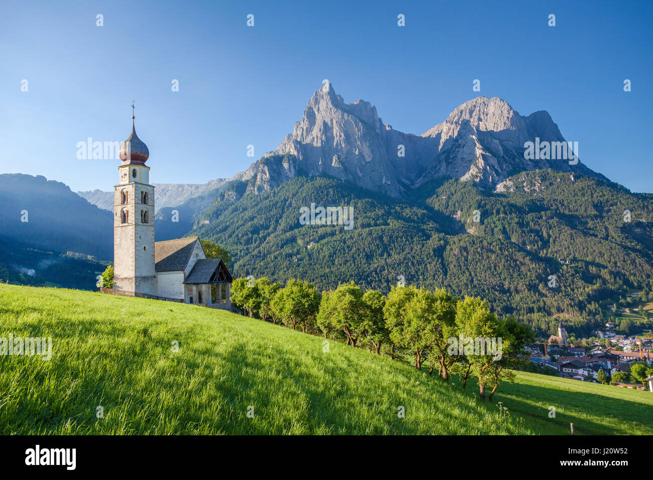 Vista panoramica di idilliaco paesaggio di montagna delle Dolomiti con la chiesetta di San Valentino e il famoso monte Sciliar in bella la luce del mattino al sorgere del sole Foto Stock