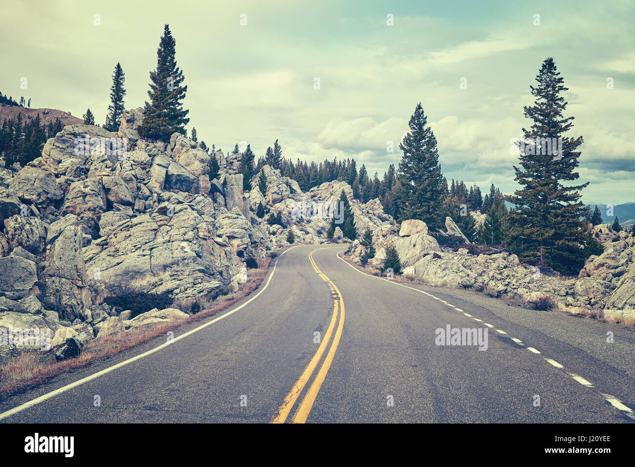 Retrò tonica scenic tortuosa strada di montagna nel Parco Nazionale di Yellowstone, Wyoming negli Stati Uniti. Foto Stock