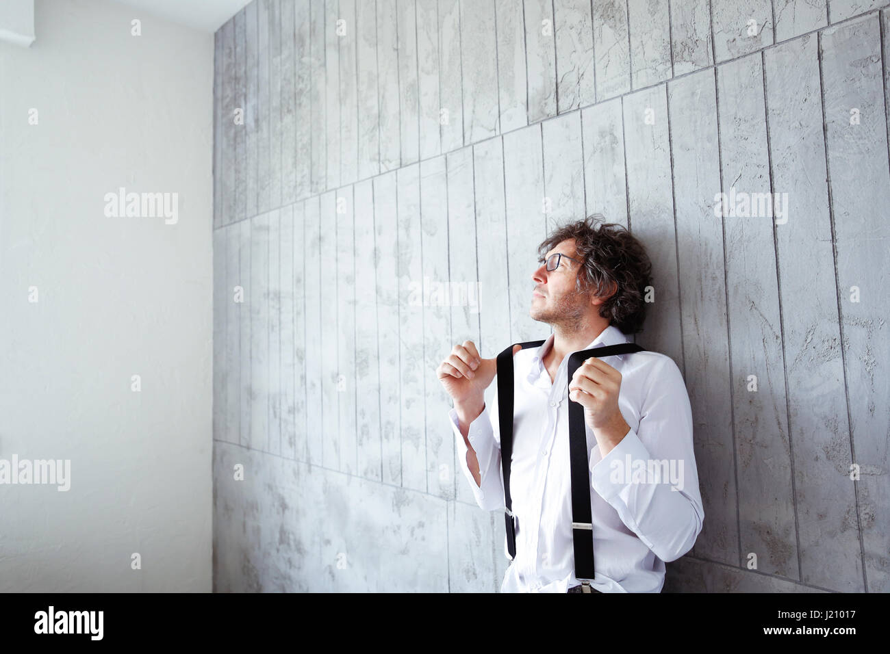 Architetto appoggiata contro la parete di cemento al sito in costruzione Foto Stock