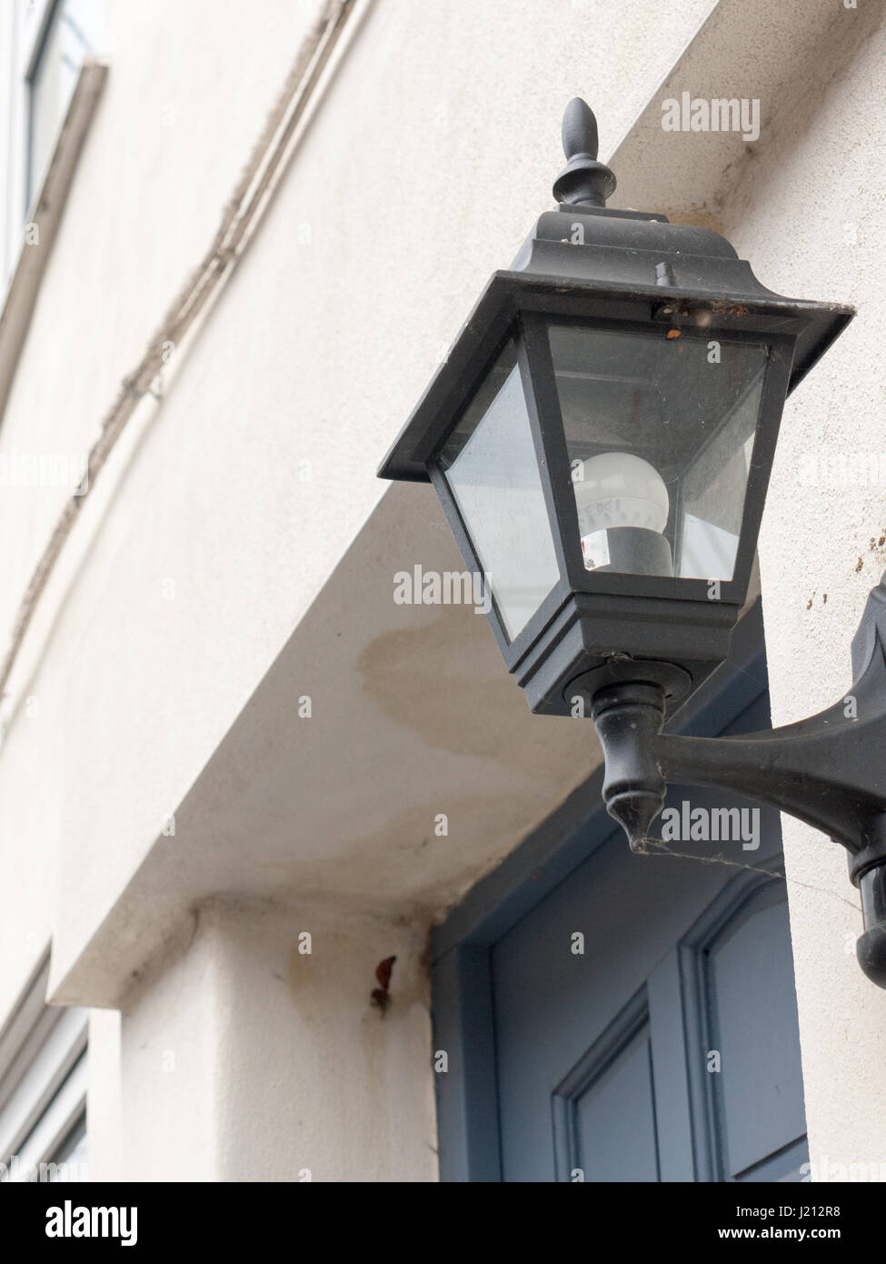 Una lanterna nera al di fuori con la luce spenta durante il giorno grave e austera in vecchio stile Victorian con pareti bianche e blu porta dietro Foto Stock
