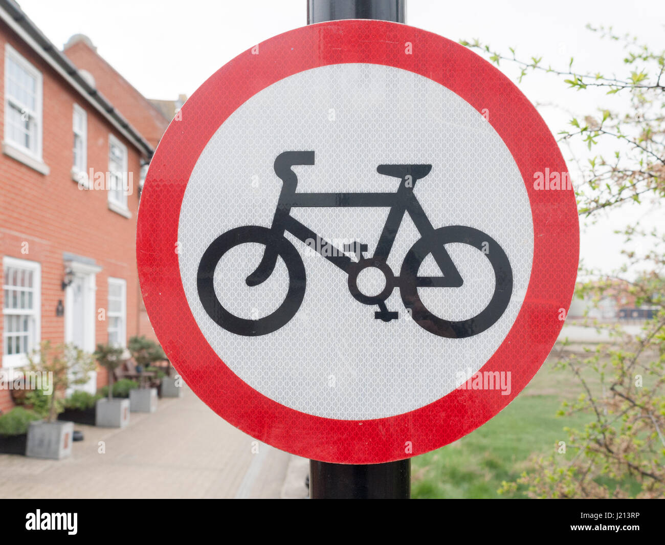 Un rosso e nero cerchio bianco segno su un palo post con una foto di una bicicletta pedali ruote consentita nessuna restrizione noleggio Inghilterra uk us public travel Foto Stock