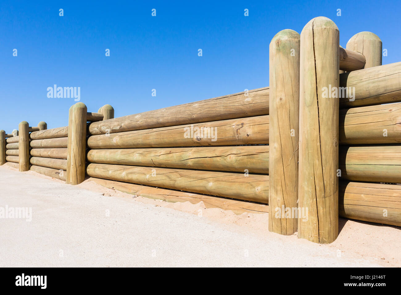 Pali di legno di confine bassa parete di recinzione closeup photo contro il cielo blu Foto Stock
