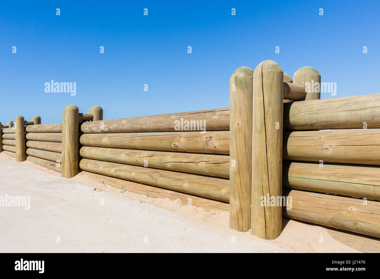 Pali di legno di confine bassa parete di recinzione closeup photo contro il cielo blu Foto Stock