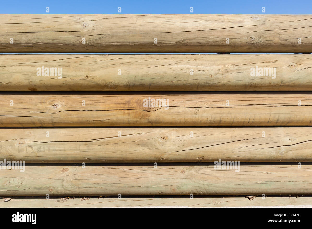 Pali di legno di confine bassa parete di recinzione closeup photo contro il cielo blu Foto Stock