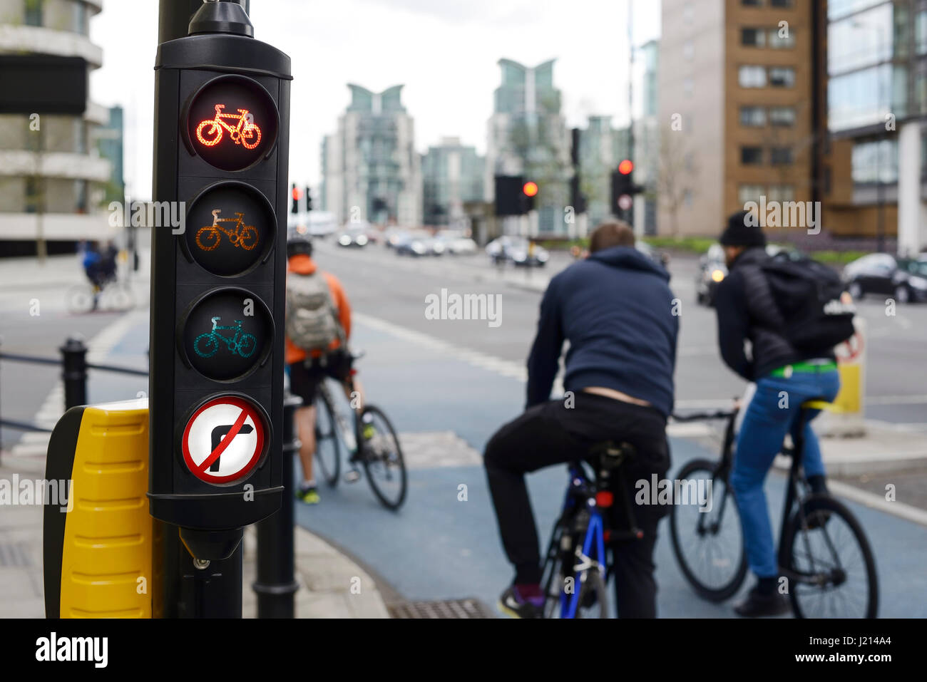 I ciclisti di attendere presso il semaforo rosso per una pista ciclabile nel central London REGNO UNITO Foto Stock