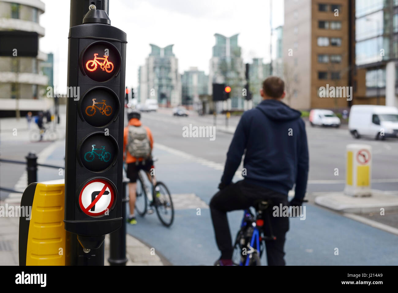I ciclisti di attendere presso il semaforo rosso per una pista ciclabile nel central London REGNO UNITO Foto Stock