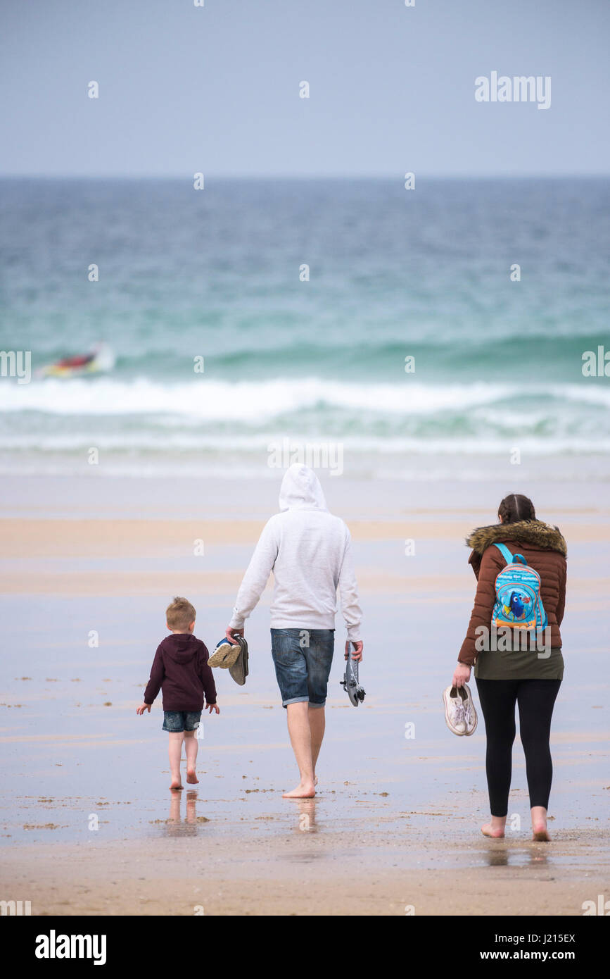 Una famiglia a piedi su Fistral Beach in Newquay, Cornwall. Foto Stock