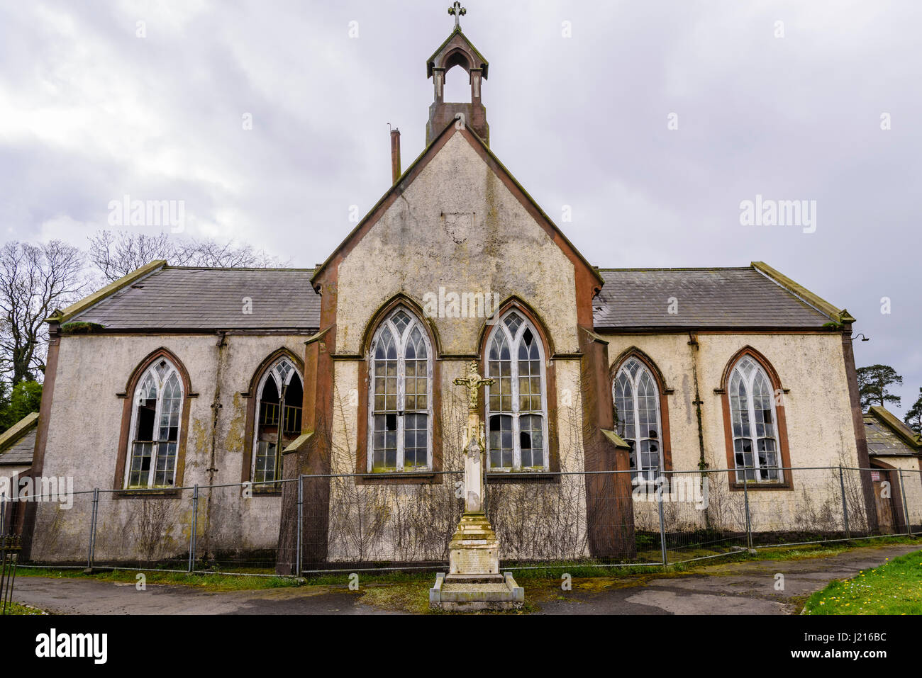 Crocifisso al di fuori di un derelitti chiesa cattolica romana Foto Stock