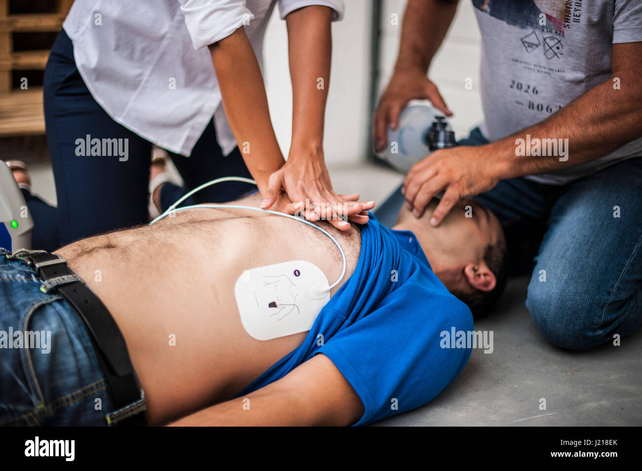 Una ragazza aiutando un ragazzo dopo un attacco di cuore con la rianimazione cardiopolmonare Foto Stock