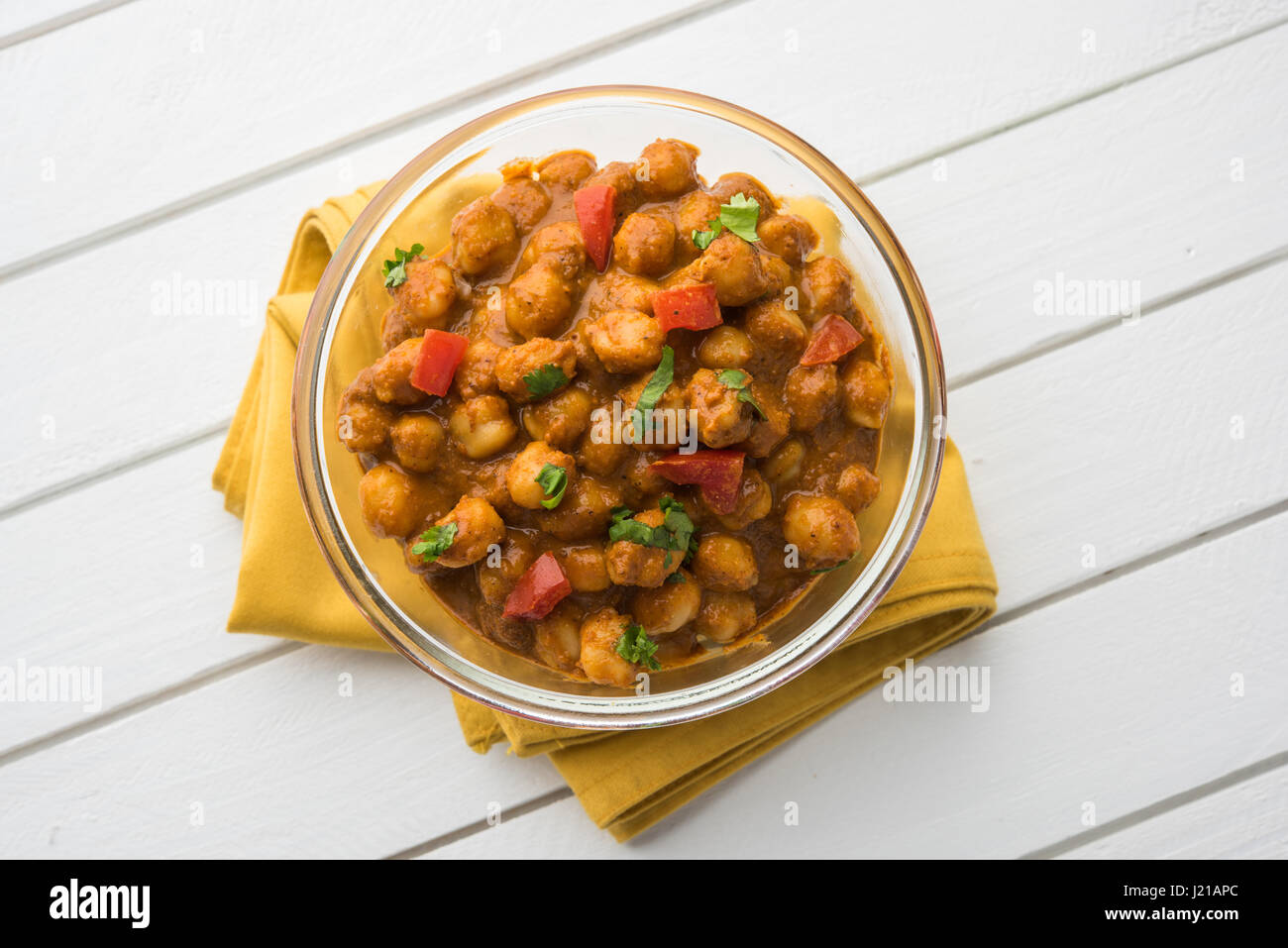 Piccante di ceci curry o Chola Masala o Chana Masala o chole bhature o choley guarnita con la cipolla tagliata a fettine e verde foglia di coriandolo, focu selettiva Foto Stock