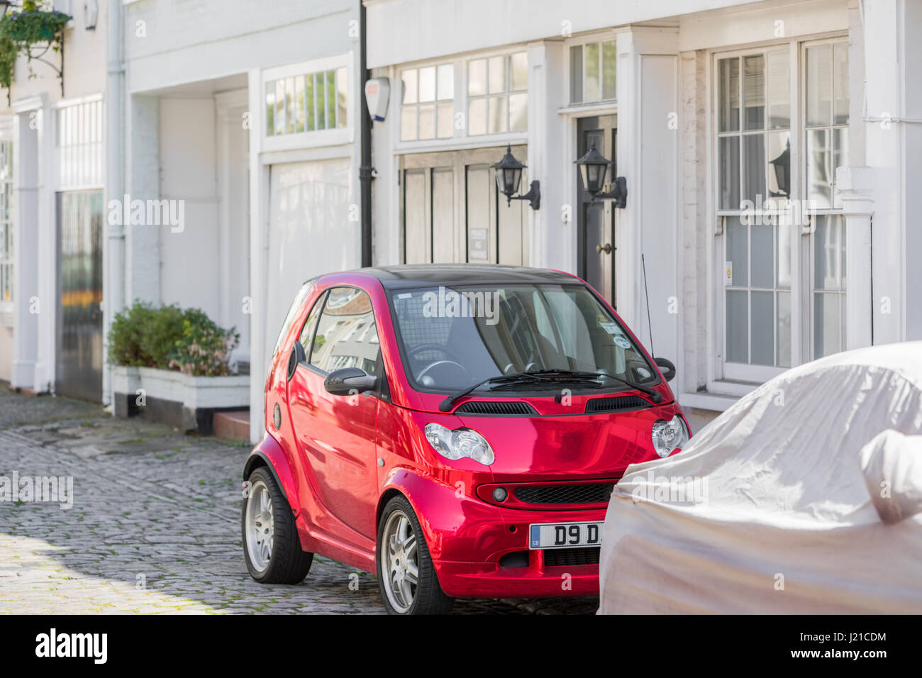 Rosso brillante elettrico smart automobile parcheggiata su una strada di Londra, London, England, Regno Unito Foto Stock
