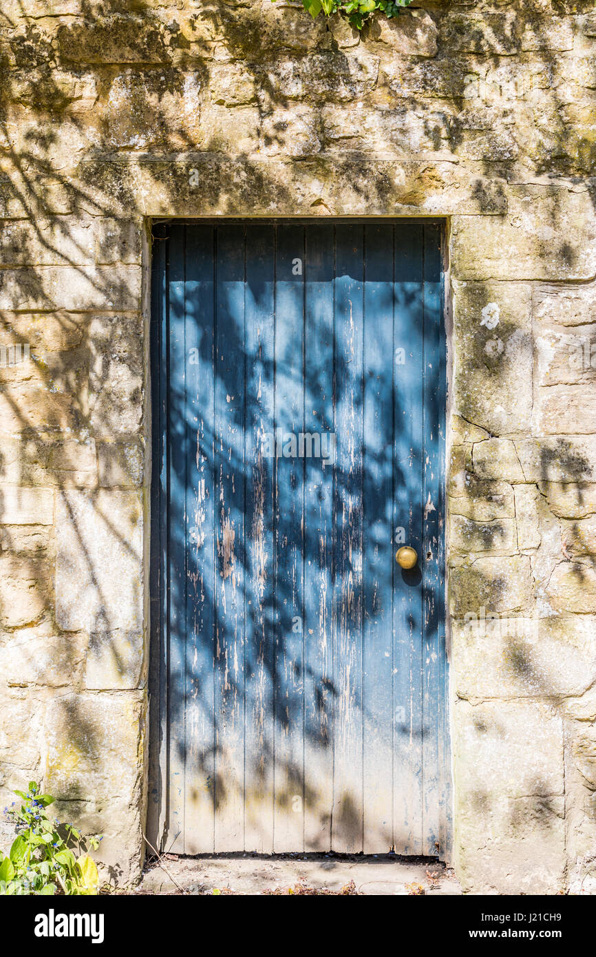 Un vecchio blu porta in un muro di pietra a Bath in Inghilterra, Regno Unito Foto Stock