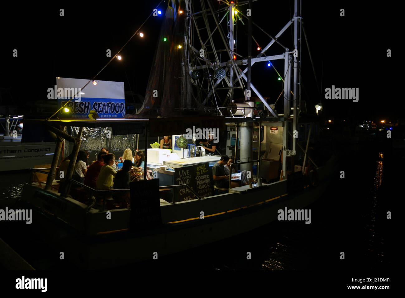 Persone mangiare a stella di gamberi, trawler convertito in un ristorante di pesce, Cairns marina, Queensland, Australia. No signor o PR Foto Stock