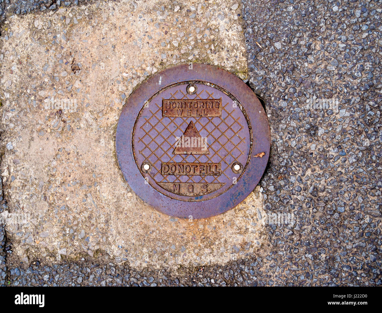 Un coperchio in acciaio su un terreno per il monitoraggio delle acque ben marcato 'Non riempire" Foto Stock