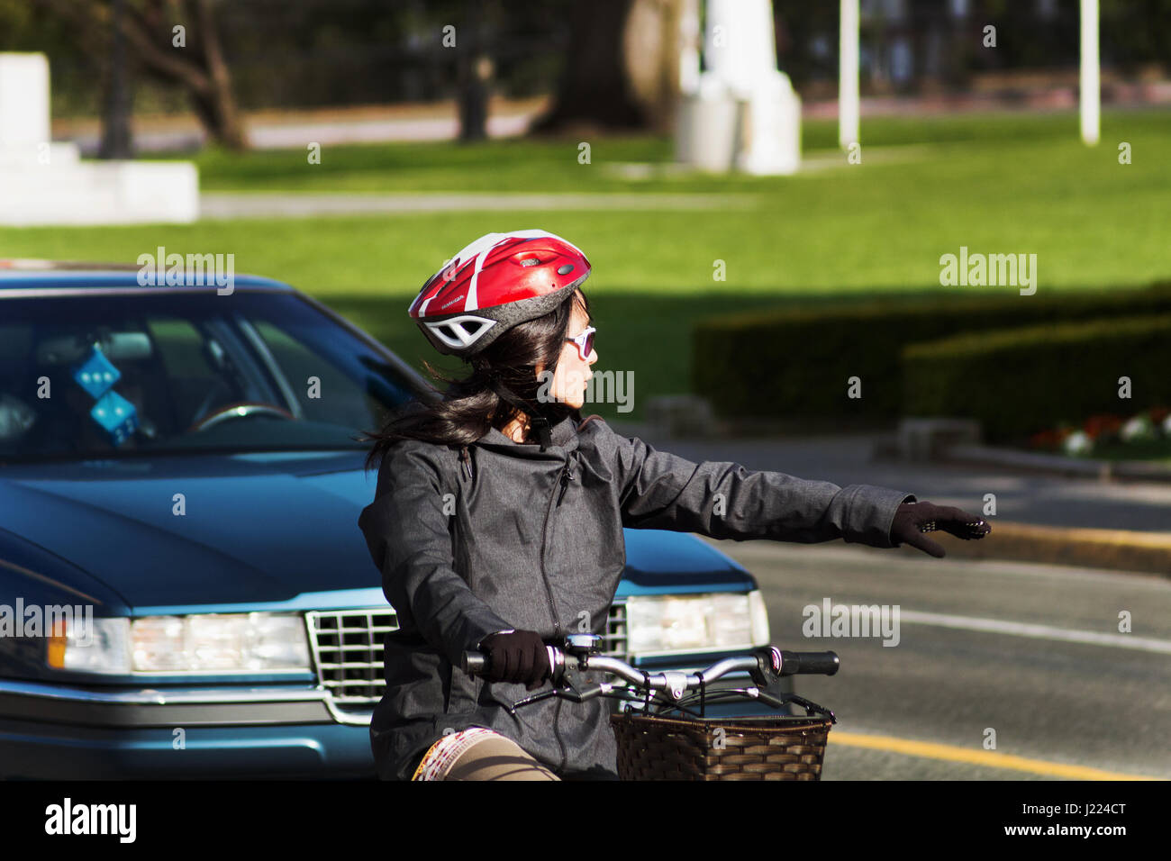 Donna in bicicletta facendo girare a sinistra. Victoria BC Canada Foto Stock