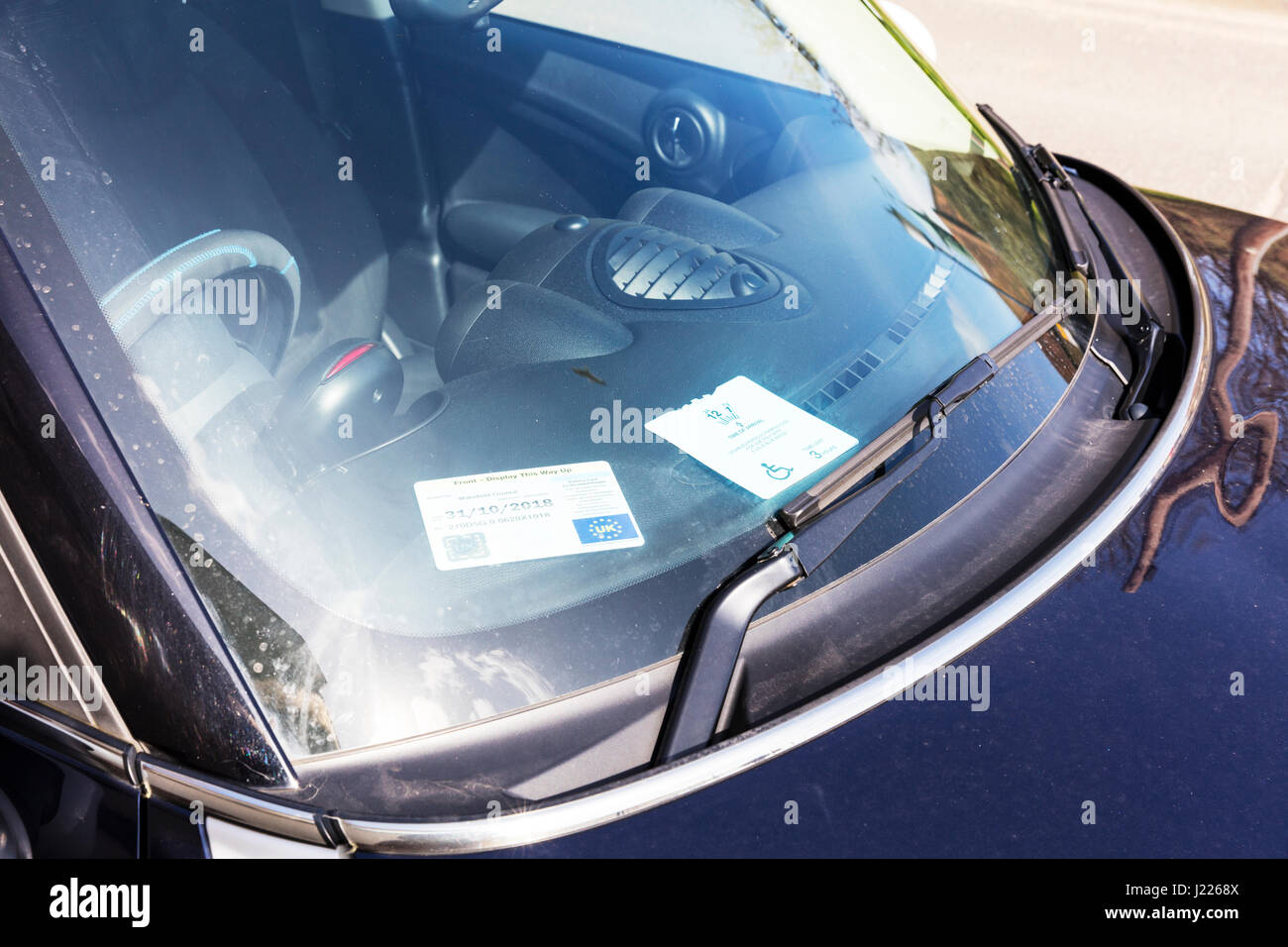Parcheggio disabili badge nella finestra auto parcheggio auto gratuito spazio per i possessori di badge REGNO UNITO Inghilterra disabilità distintivo di parcheggio Foto Stock
